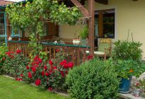 Gemütliche Terrasse mit Blumenbeet, Stühlen und Blick auf das Haus Obersamer im Raurisertal.