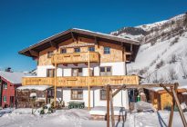 Haus Obersamer im Raurisertal, umgeben von Schnee und Bergen, ideal für Winterurlaub.